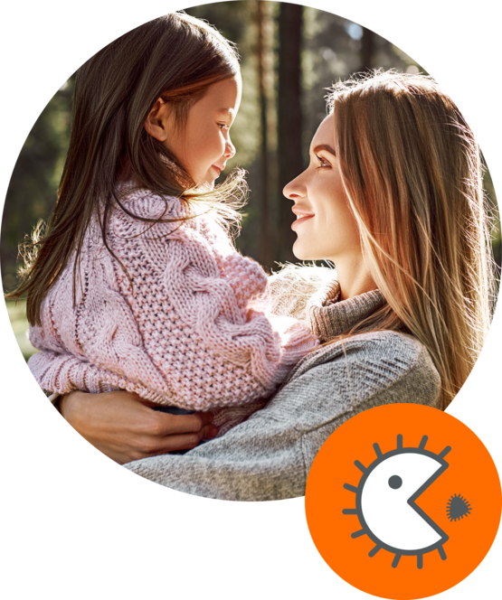 Mother holding her daughter outdoors, both smiling at each other, framed by a circular graphic with an orange icon representing a bacteria with a face.